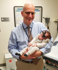 Emma Williams with William Goodnight, MD, the maternal-fetal medicine doctor who treated her and her mom, when she was a newborn