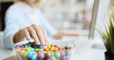 Woman reaches for a bowl of colorful candies