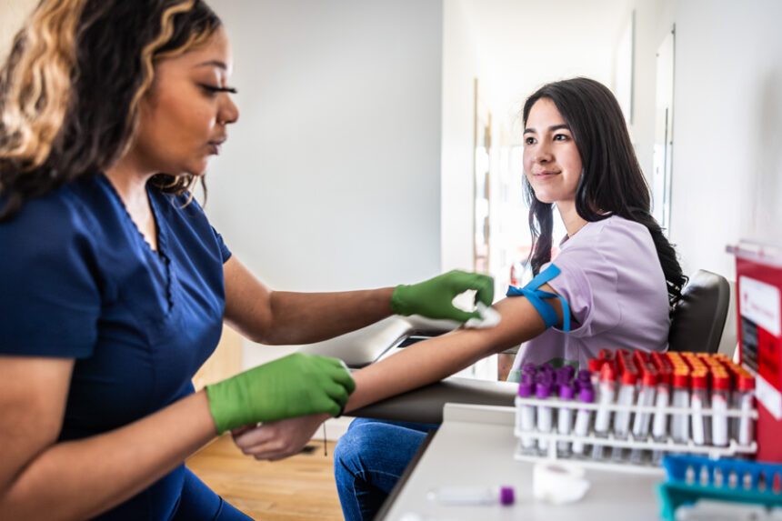 A healthcare professional draws blood from a patient in a medical office.