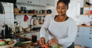 Woman preparing a fresh salad in her kitchen.