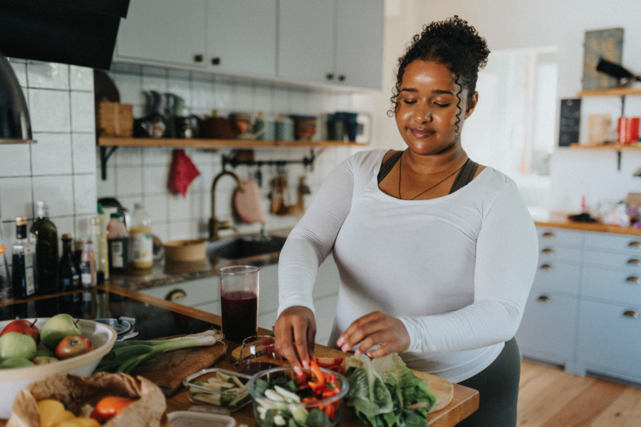 Woman preparing a fresh salad in her kitchen.