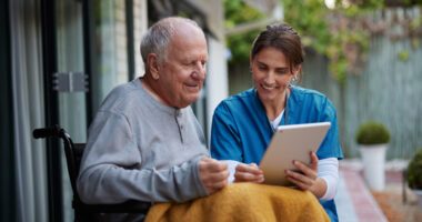 A nurse supporting a patient as they review information together.