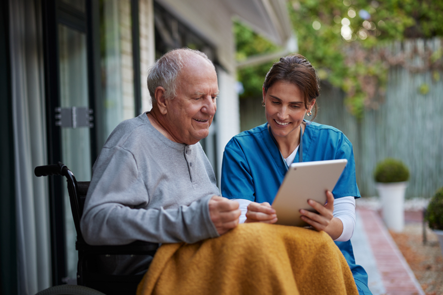 A nurse supporting a patient as they review information together.