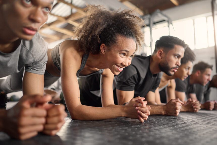 people in fitness class perform a plank move