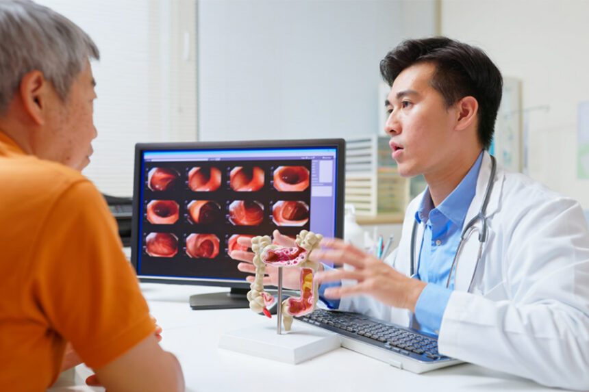 Provider speaks to patient with demonstratives of a stomach/intestine model and images of a colon on a computer screen