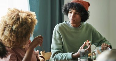 mom and teen son talk at the kitchen table