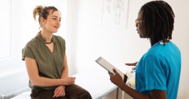 Female patient talks to female provider in an exam room