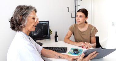 Young woman consults with healthcare professional holding a tablet