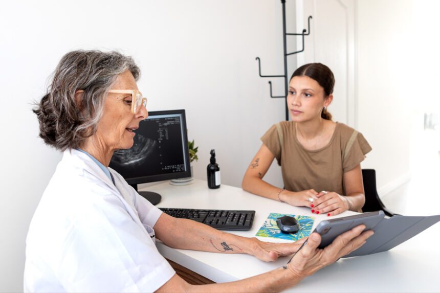 Young woman consults with healthcare professional holding a tablet