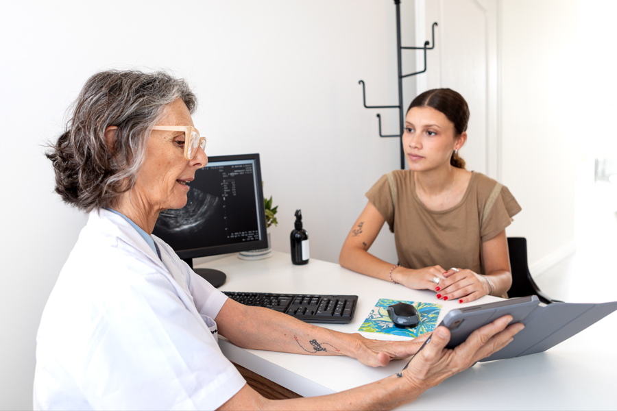 Young woman consults with healthcare professional holding a tablet