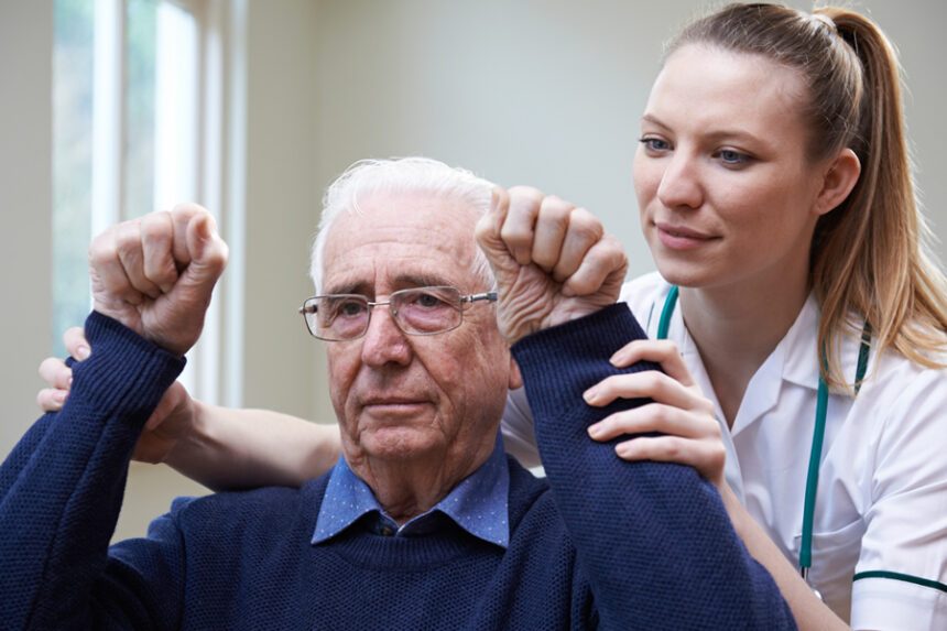 Provider helps an elderly man participate in physical therapy