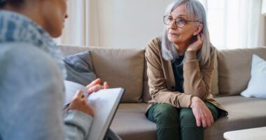 An older woman speaks with a mental health professional during a counseling session.