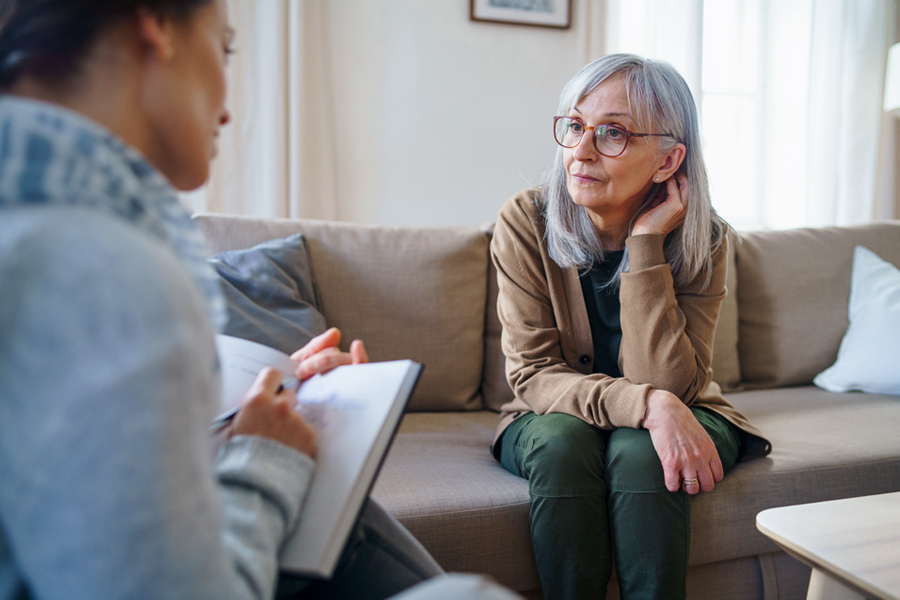 An older woman speaks with a mental health professional during a counseling session.