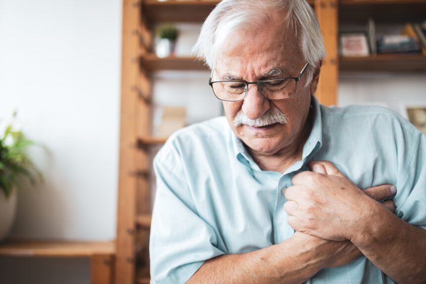 senior man clutches his chest in pain