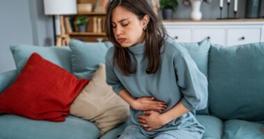 woman clutches abdominal area in pain