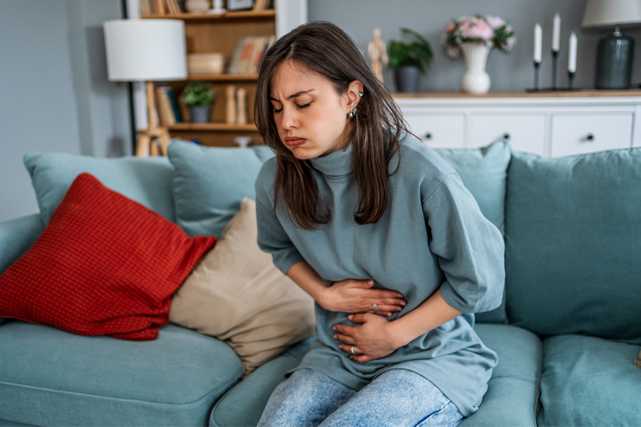 woman clutches abdominal area in pain
