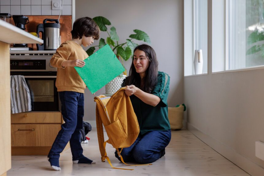 Mom helping her son get ready to go back to school.