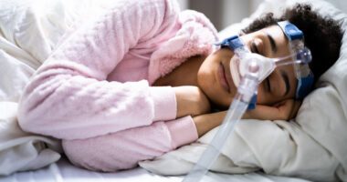 woman sleeps with CPAP machine over her face