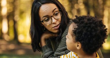 A mother and her son having a conversation at the park.