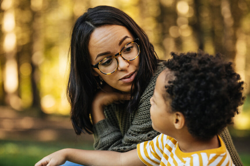 A mother and her son having a conversation at the park.