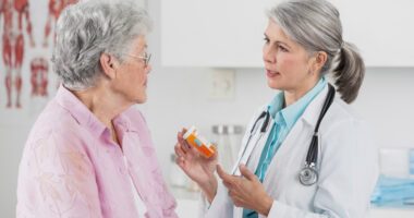 provider talks to patient, holding a medicine bottle