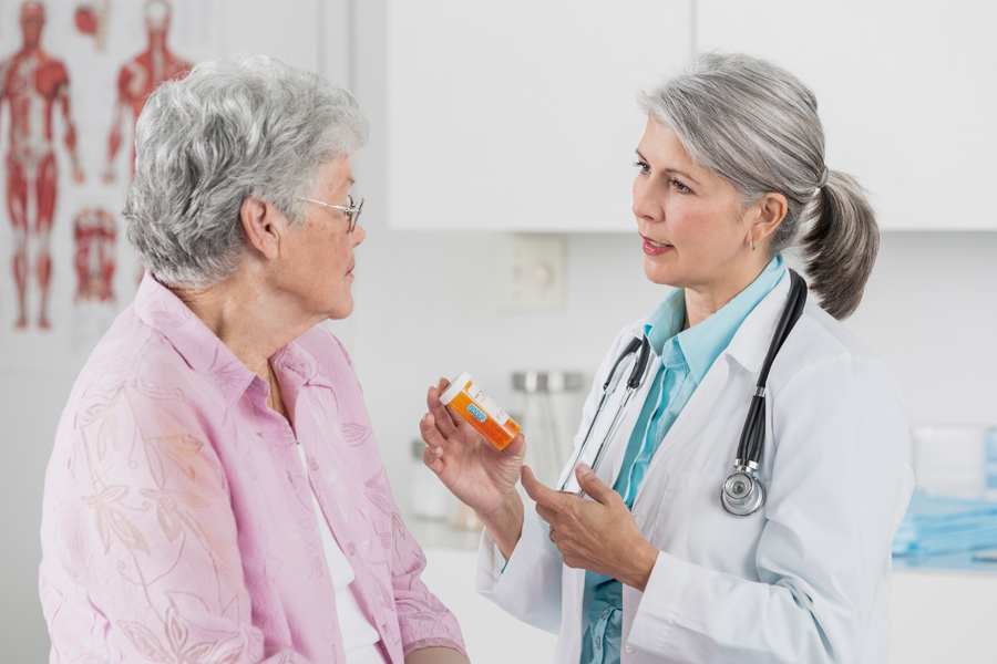 provider talks to patient, holding a medicine bottle